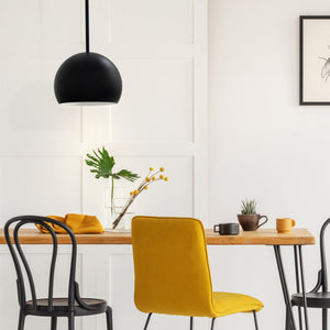 Tivoli matte black dome pendant above a small dining table.